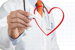 Male doctor drawing heart symbol at the whiteboard